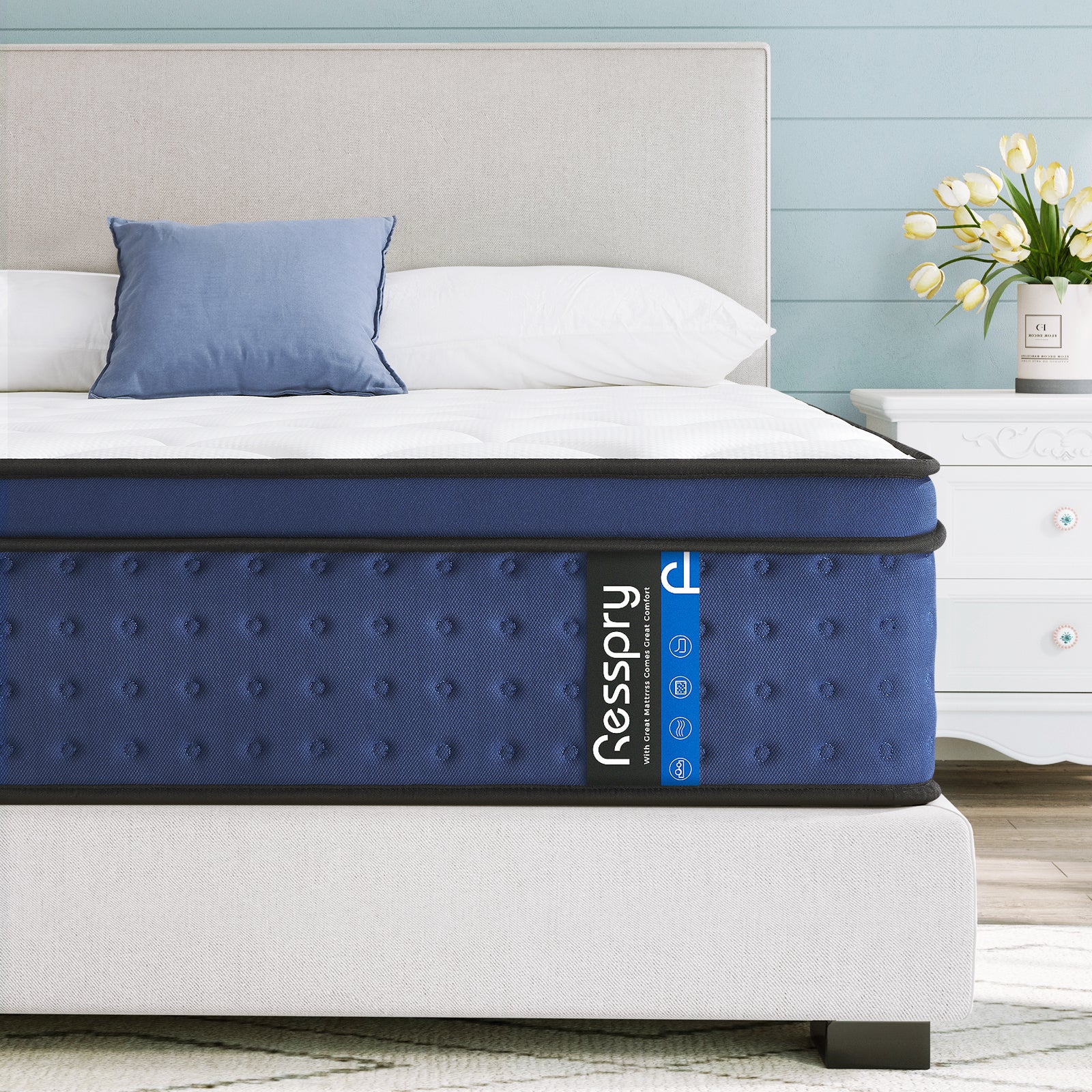 A navy-colored hybrid mattress with breathable foam and individually pocketed springs, displayed on a bed frame in a room setting.